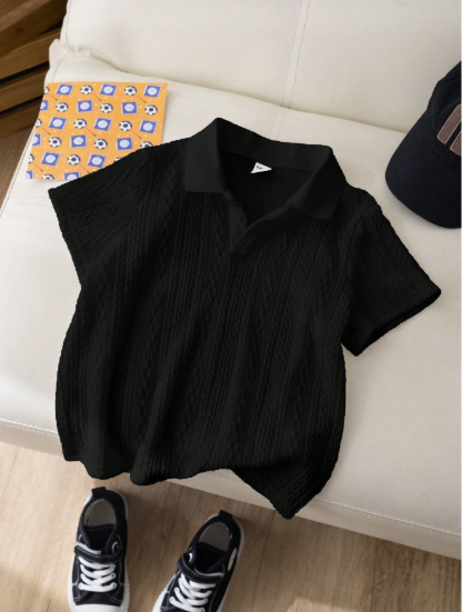Black polo shirt on a white couch with a cap and sneakers in front